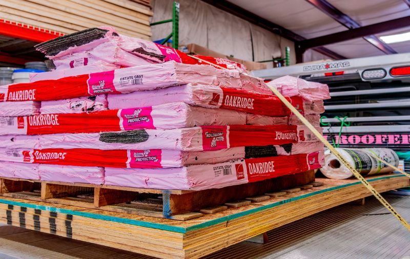 A pallet of insulation is sitting on top of a wooden pallet in a warehouse.