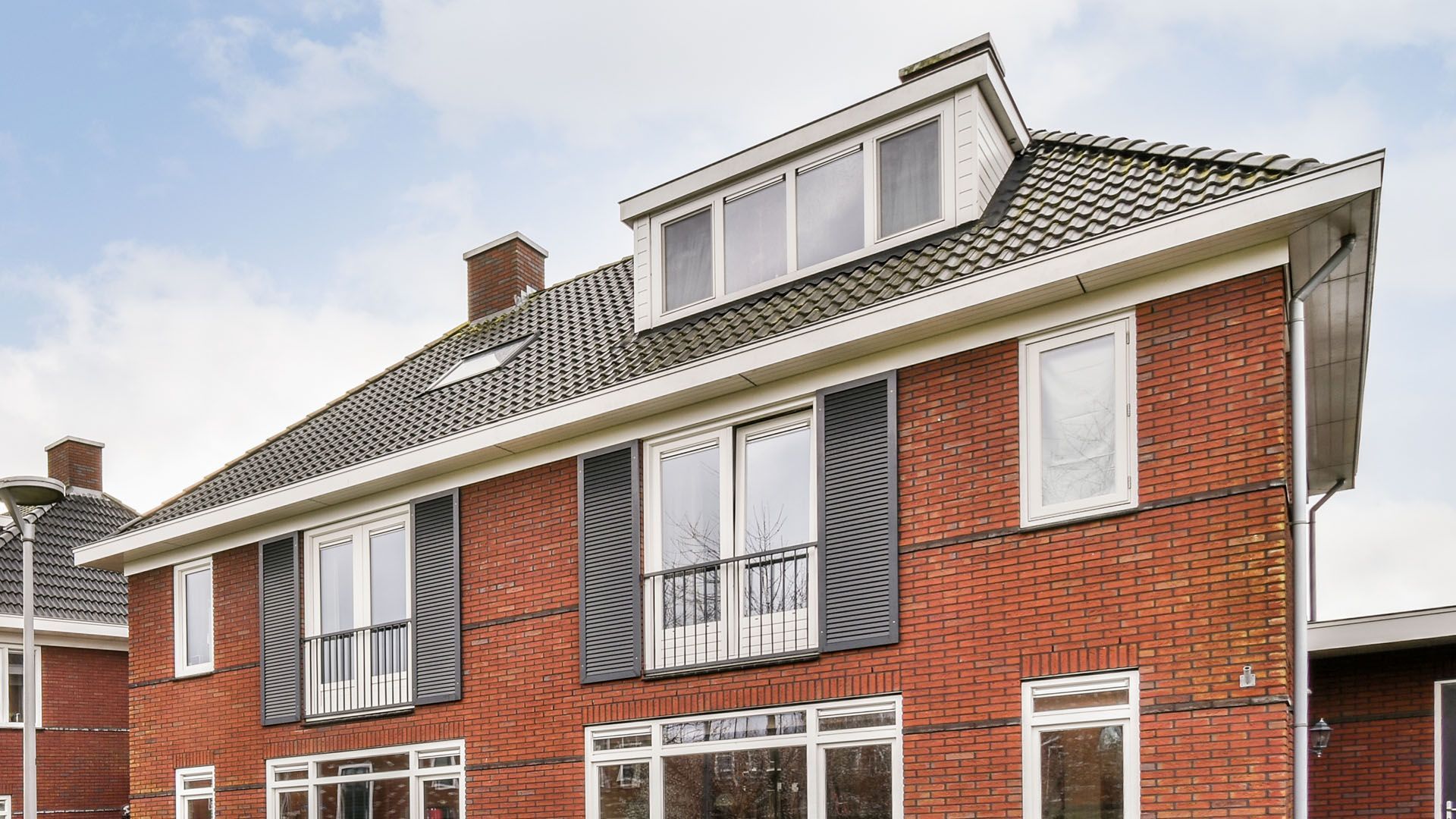 A large red brick house with grey roofing