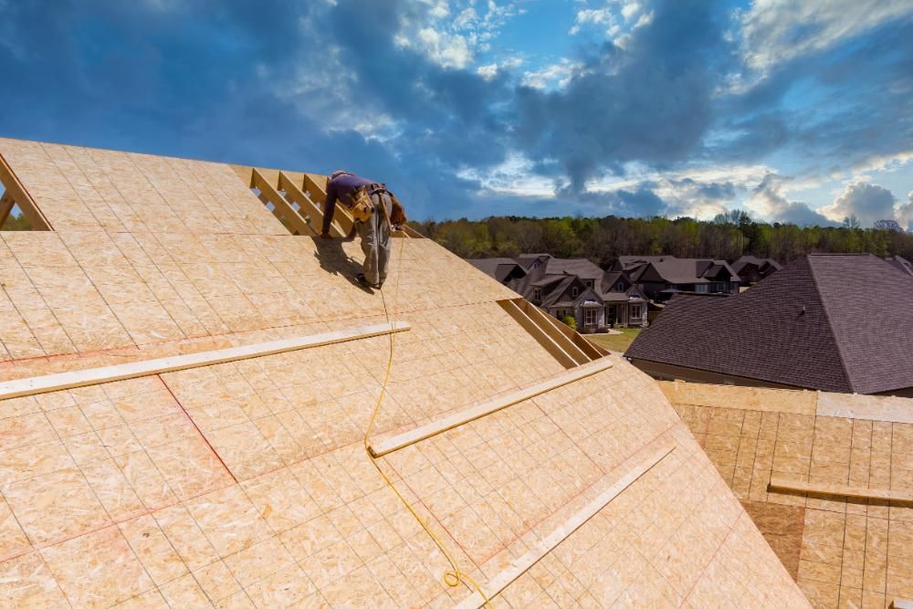 A man is working on the roof installing underlayment