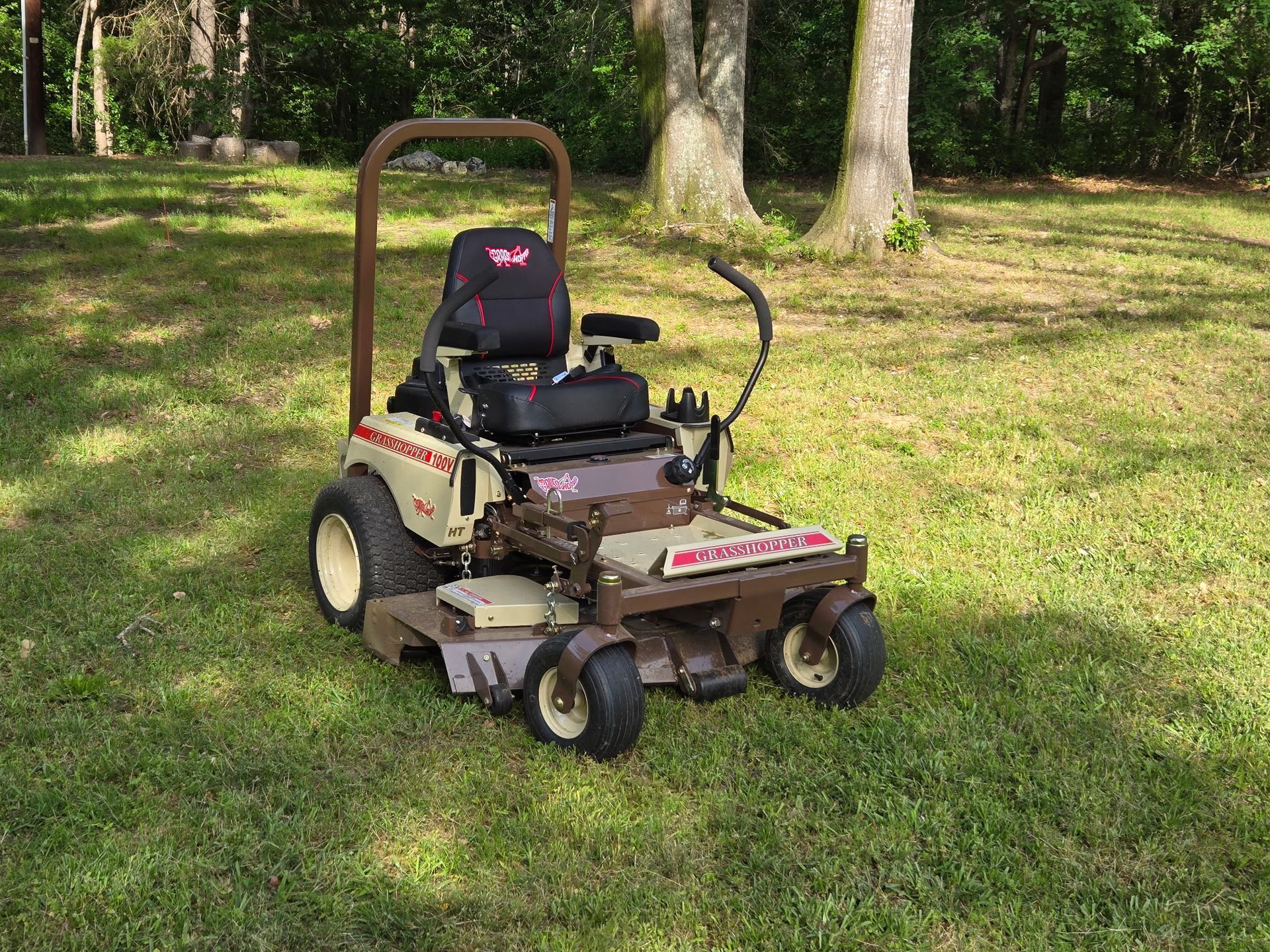 A brown and white lawn mower is sitting on top of a lush green lawn.