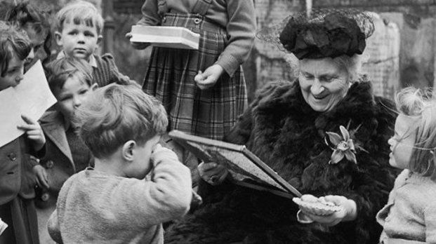 black and white image of Maria Montessori surrounded by children