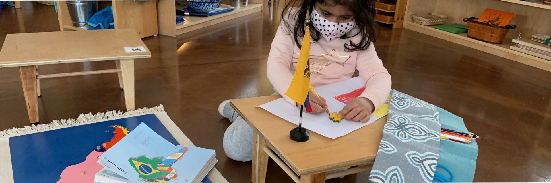 Preschool aged child with continents map and national flags