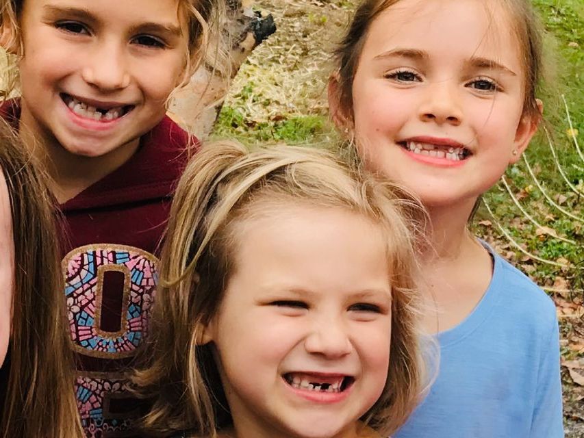 Image of smiling children who are all missing their front teeth