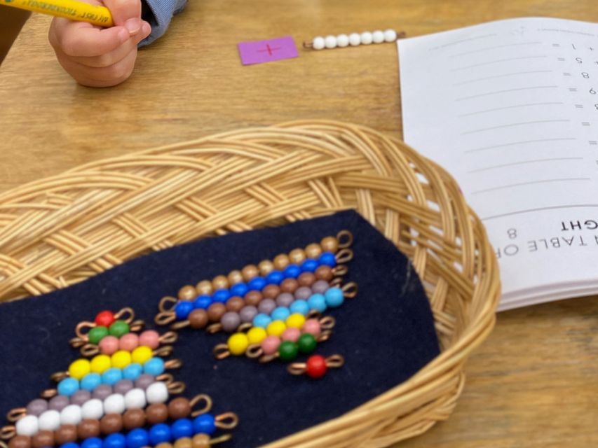 A basket of bead bars sitting on a table next to an open workbook