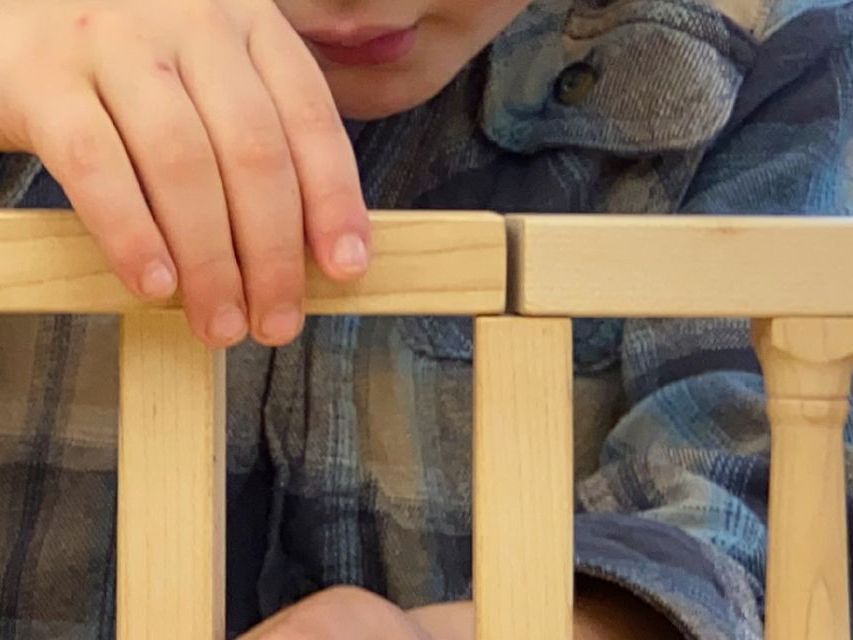 zoomed in image of a child's hands building a bridge with blocks.