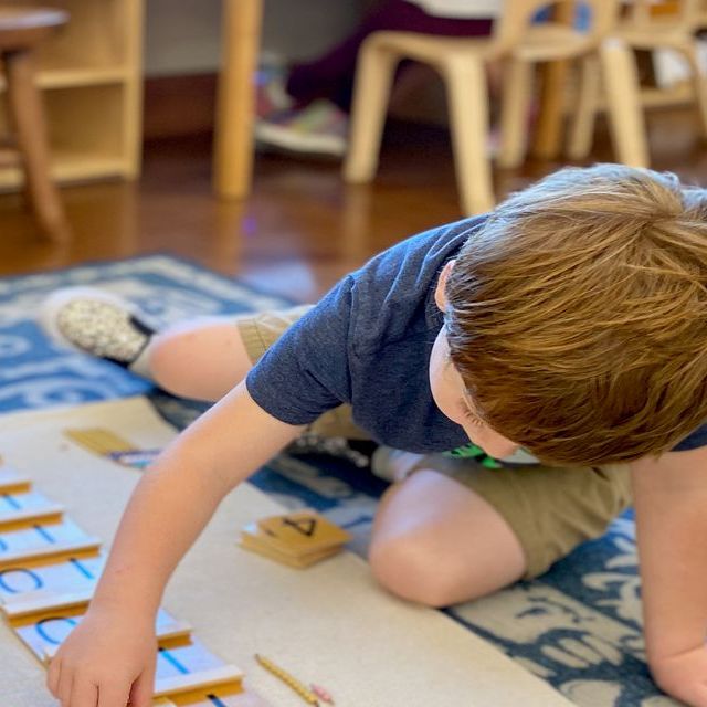 Child with clear plastic primary colors discs, looking through red and yellow together