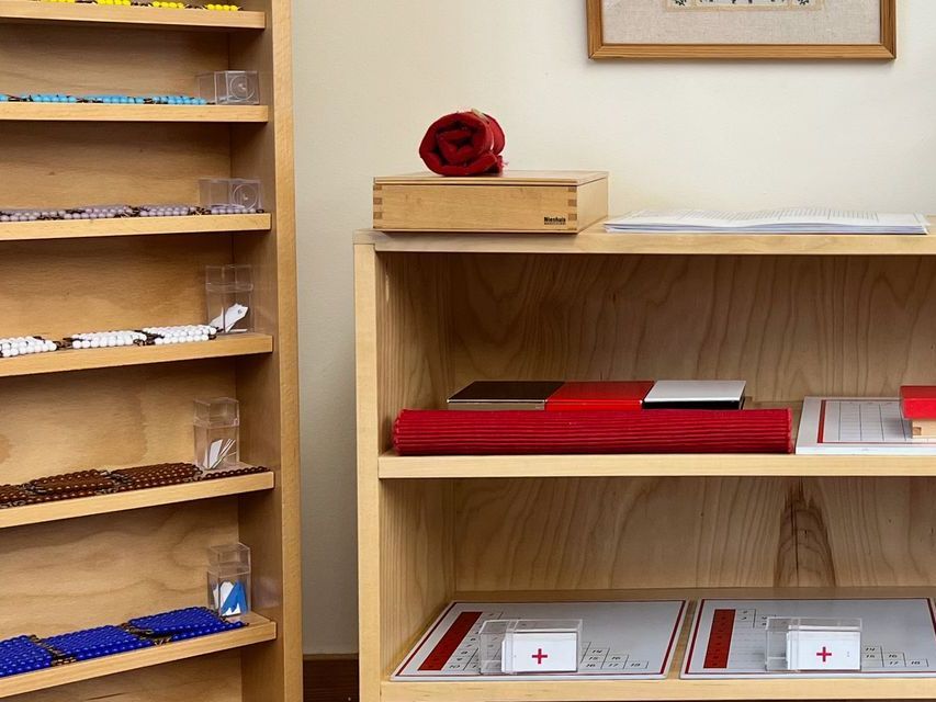 image of two adjacent bookshelves filled with Montessori materials