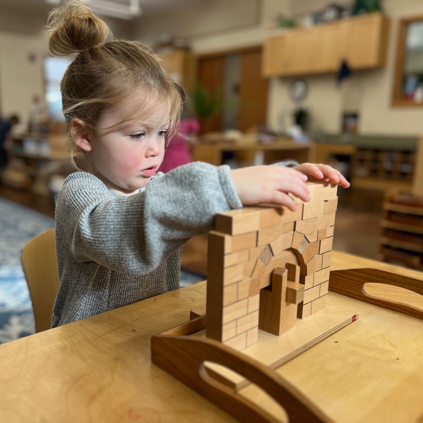 preschool child with arch building block lesson