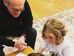 Image of a grandfather working with his grandchild on the floor with Montessori materials