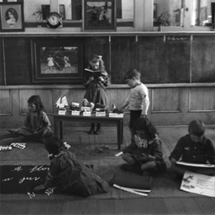 historical black and white image of children with lessons