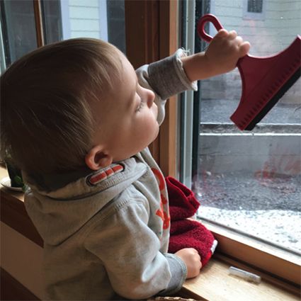 Toddler with squeegee at window