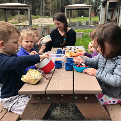 Toddlers and guide at picnic lunch