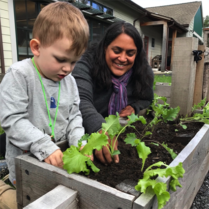 Toddler with adult at garden box