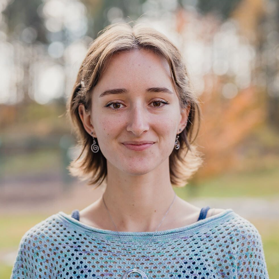 Image of a woman's face and shoulders centered in front of outdoor landscape