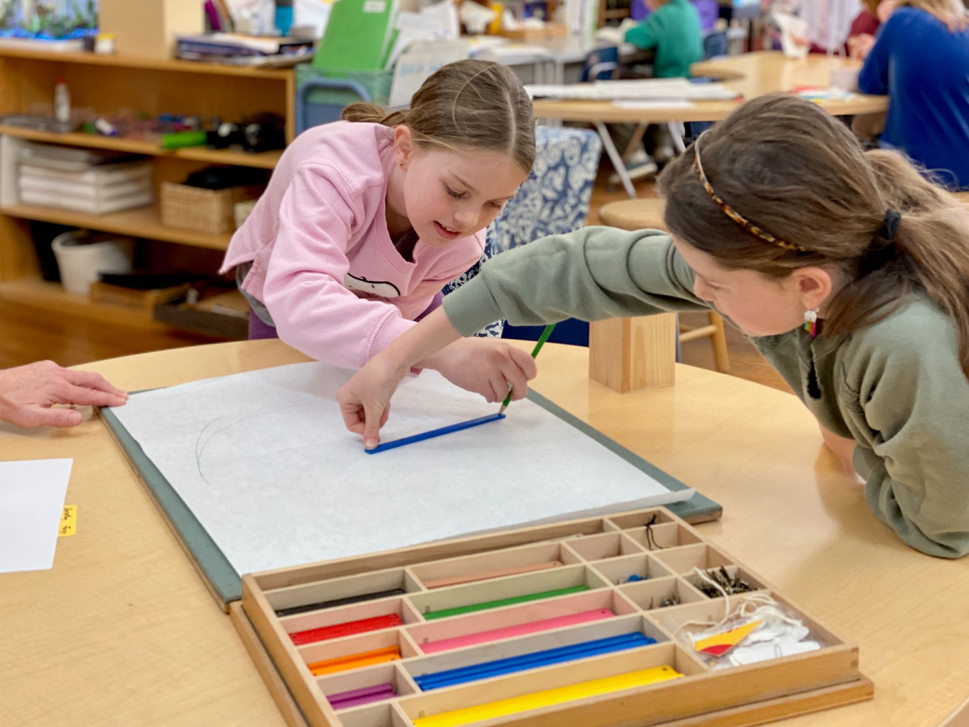 image of wo girls working together on a large pieceof paper 