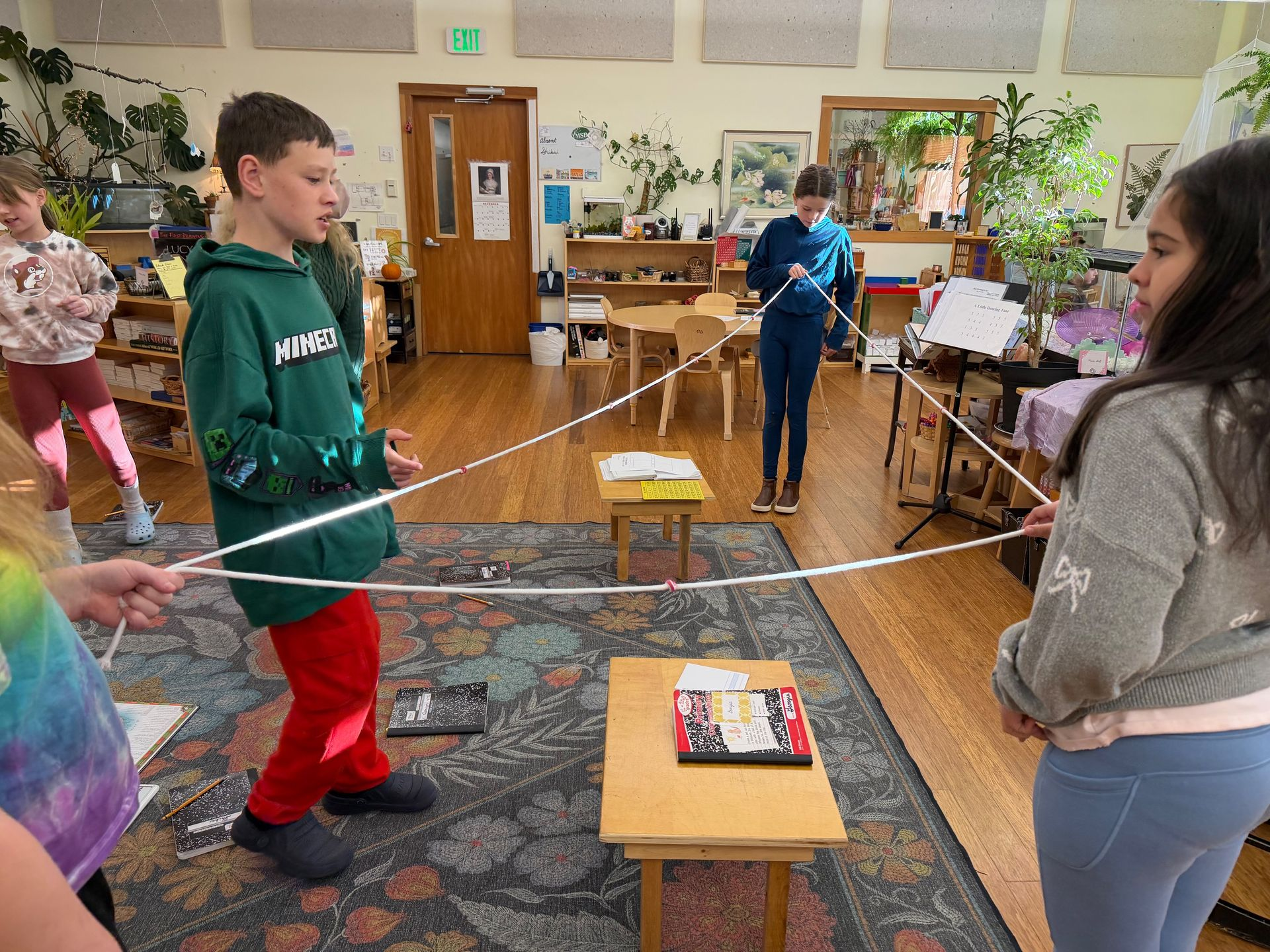 Image of three elementary students holding a triangle of rope between them