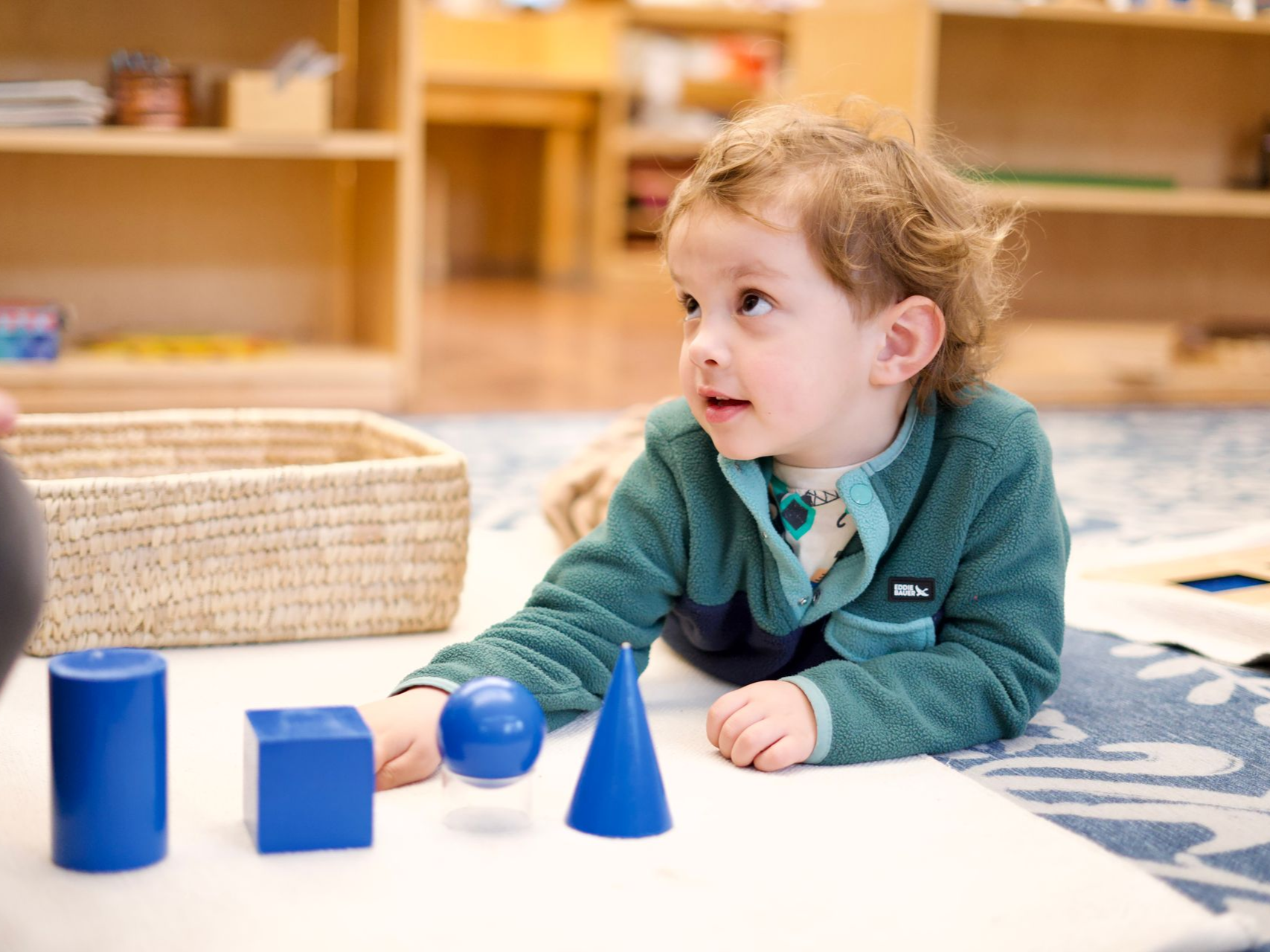 image of a preschool aged child on a carpet with the geometric prism lesson