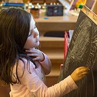 Preschool child drawing on an easel