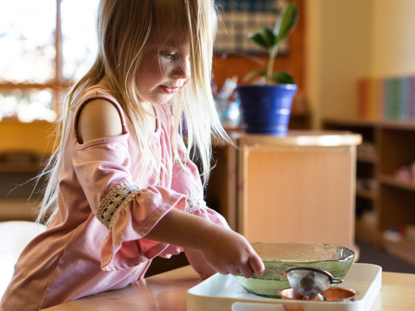 Preschool aged child working with a lesson on a tray at a small table