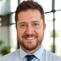 Image of Nico Forcier head and shoulders with a bright wall of windows in the background