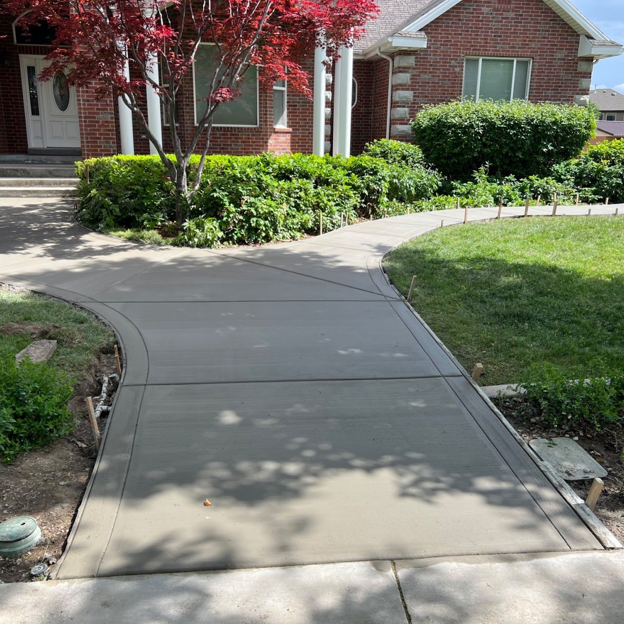 A brick house with a concrete walkway leading to it