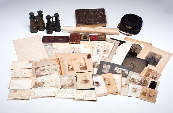 A bunch of old photographs and papers on a table