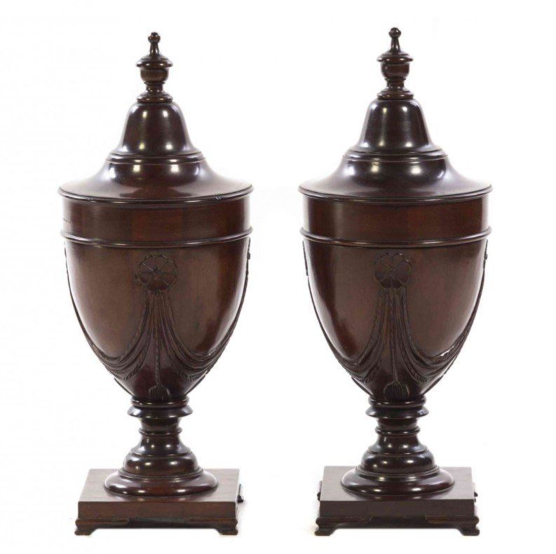 A pair of wooden urns with lids on a white background