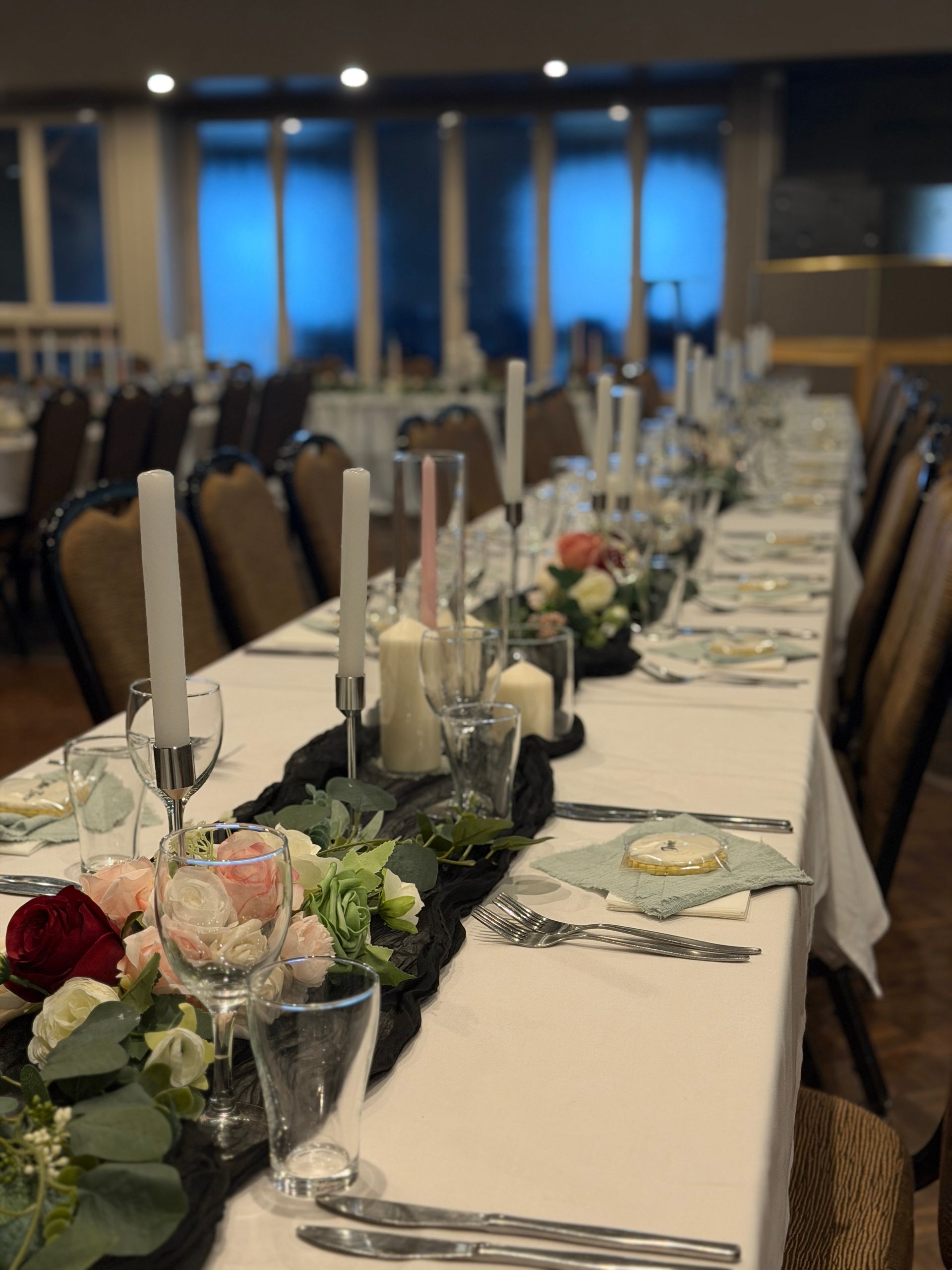 Elegant table setting at a formal event, featuring gold-rimmed plates, white napkins, and floral centerpiece.