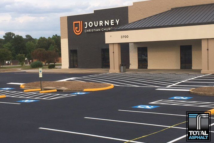 A parking lot in front of a building that says journey