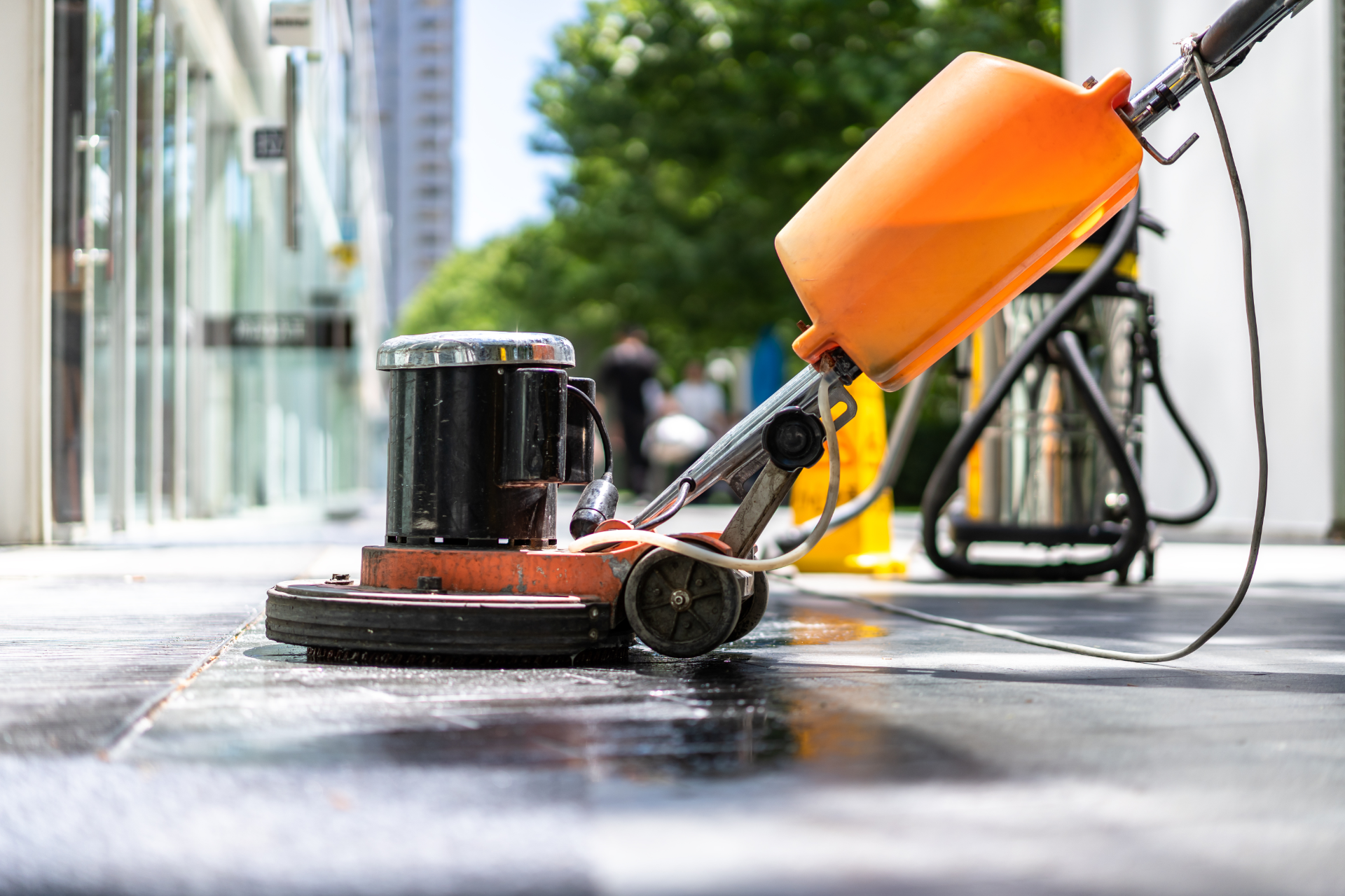 A vacuum cleaner is being used to clean a tiled floor.