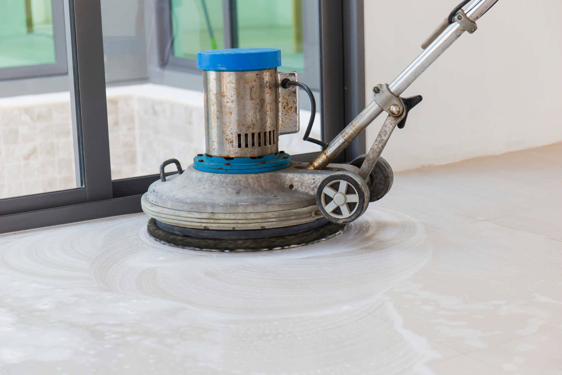 A machine is cleaning a marble floor in a room.
