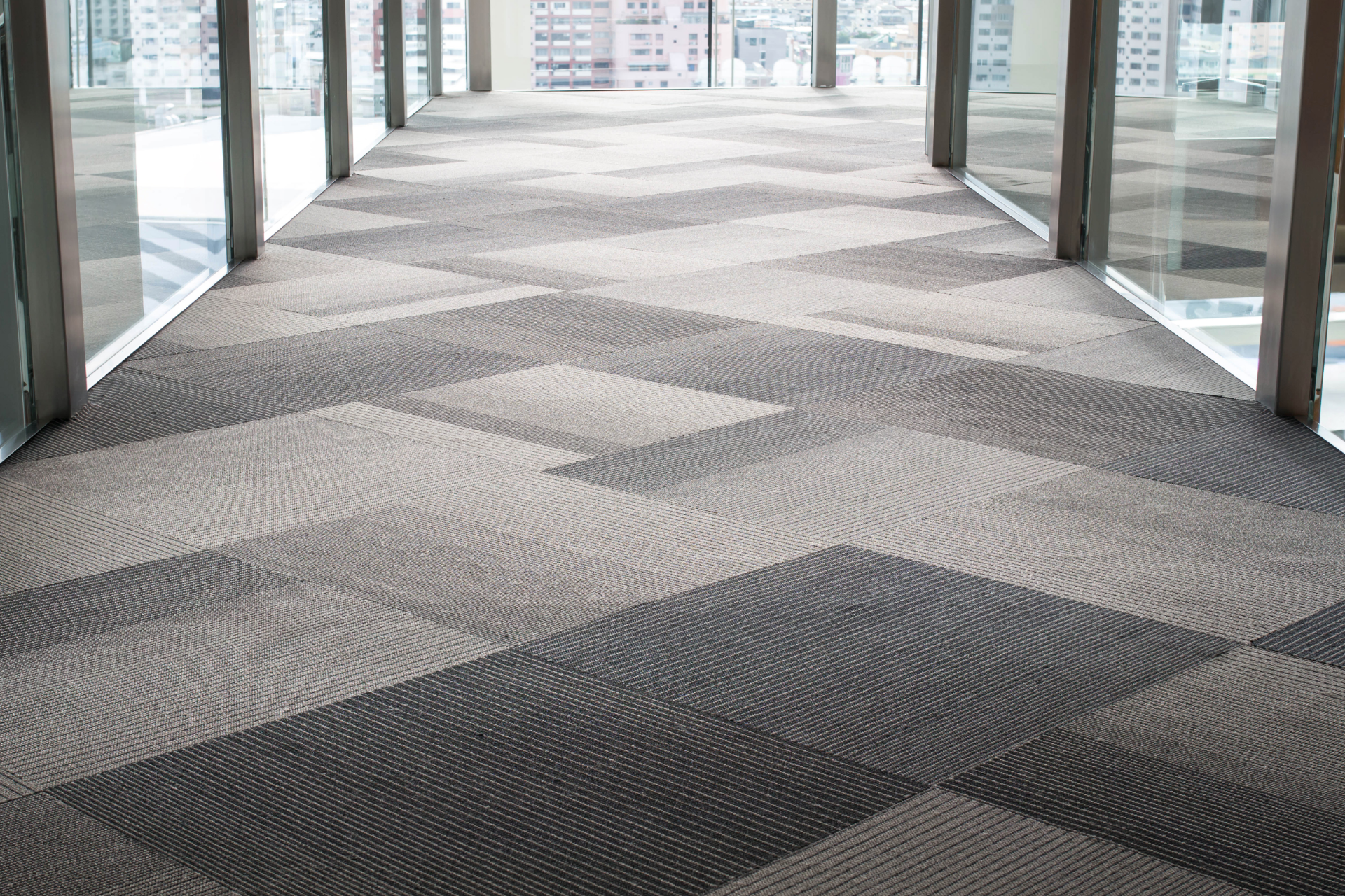 A long hallway with a carpeted floor and a lot of windows.