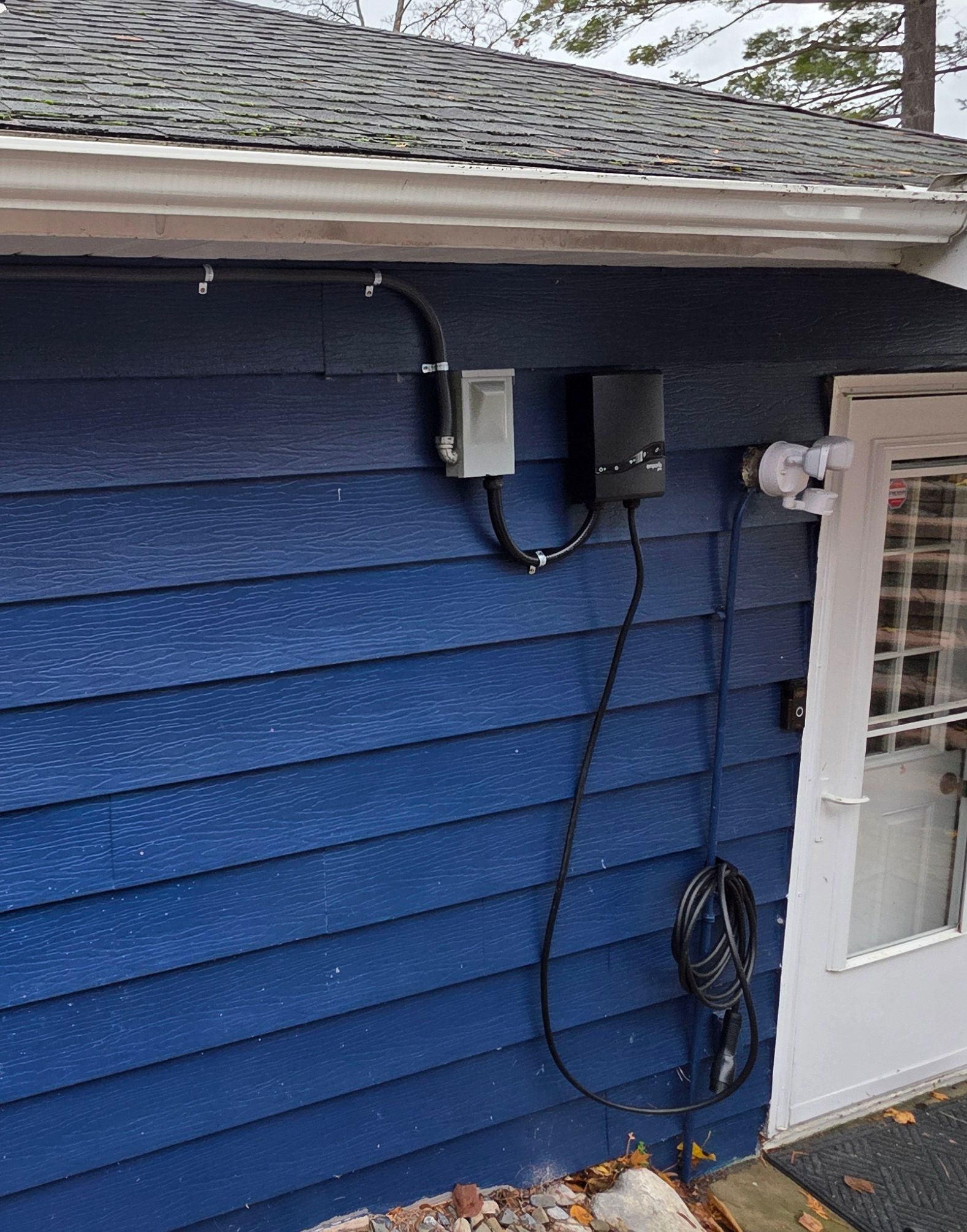 Gray electric car charging at a charging station in a parking lot.