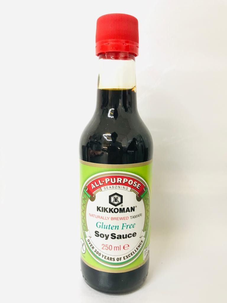 Bottiglia di salsa di soia multiuso Kikkoman con tappo rosso ed etichetta bianca su sfondo neutro.