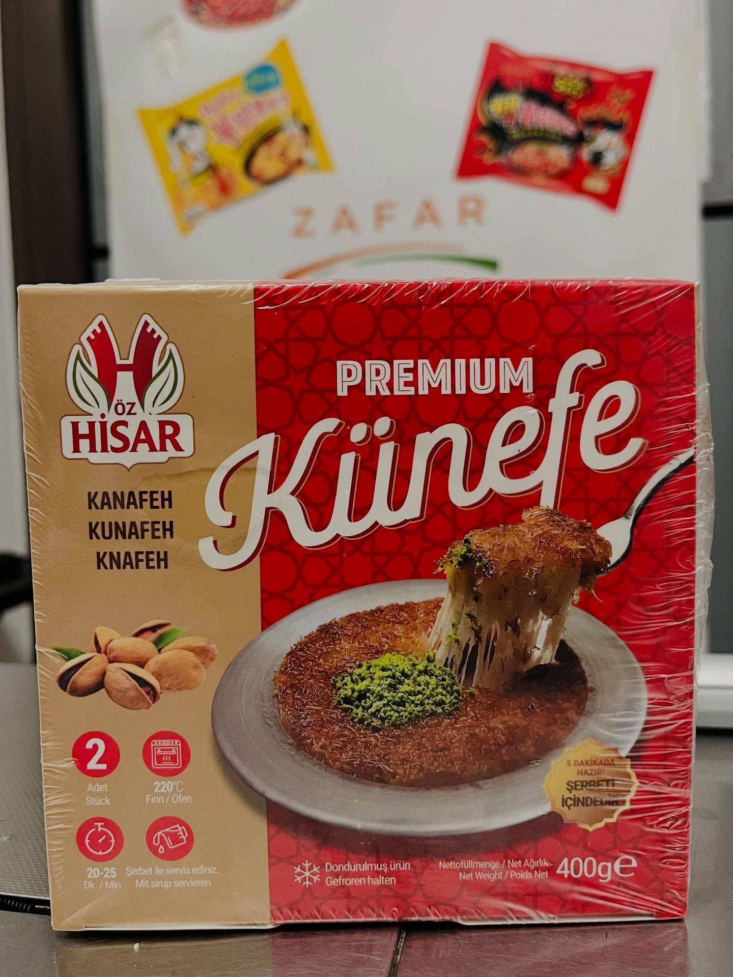 Confezione regalo premium per künefe di HISAR, nei colori rosso e beige, con una porzione di künefe servita su un piatto raffigurante la parte frontale.
