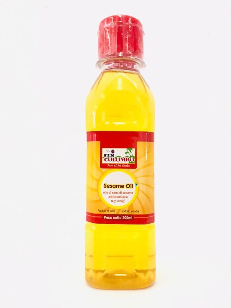 Bottiglia di olio di sesamo con tappo rosso e liquido giallo su sfondo bianco.