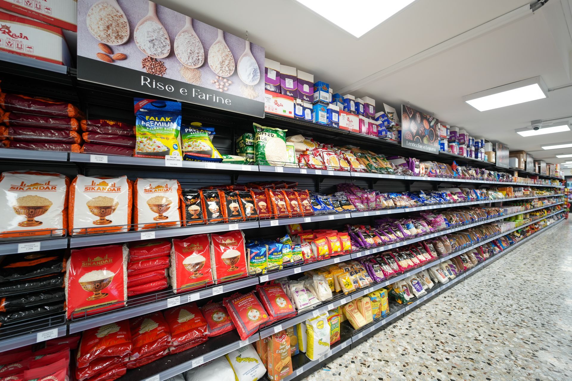 Il reparto snack di un supermercato, con scaffali pieni di cibi confezionati e colorati sotto luci intense.