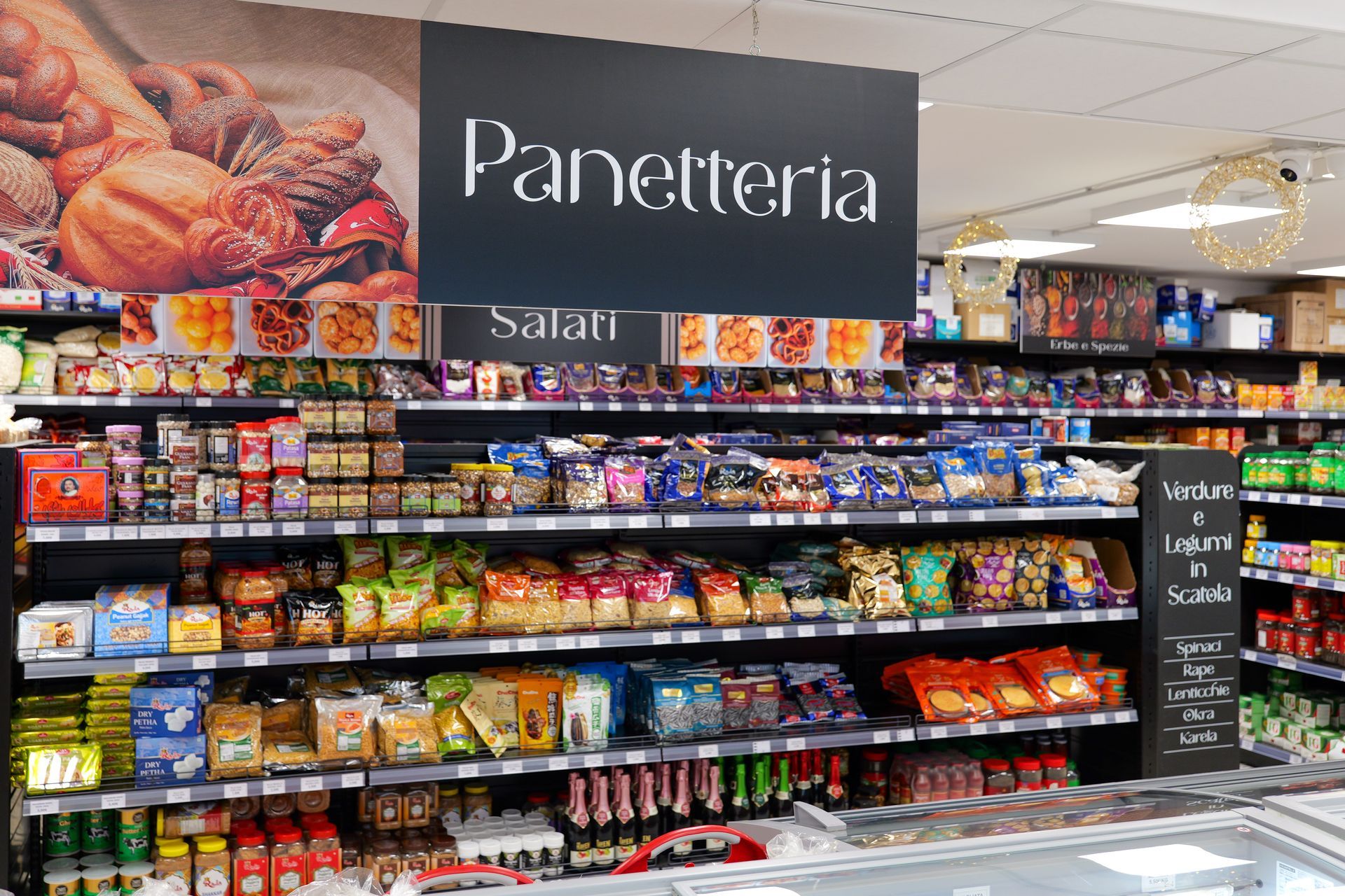 Esposizione di prodotti da forno in una panetteria, con scaffali pieni di snack confezionati e prodotti da forno in una corsia di un supermercato.