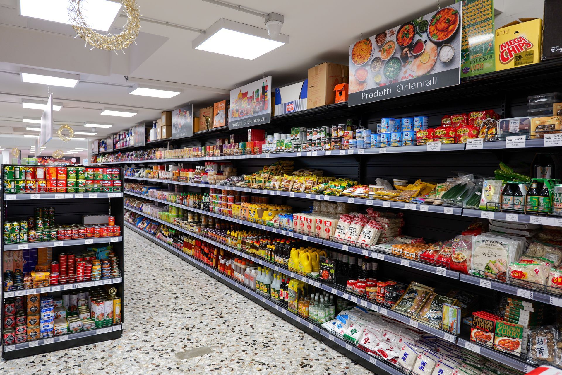 Il corridoio di un supermercato, con scaffali pieni di snack e bevande illuminati da luci fluorescenti intense.