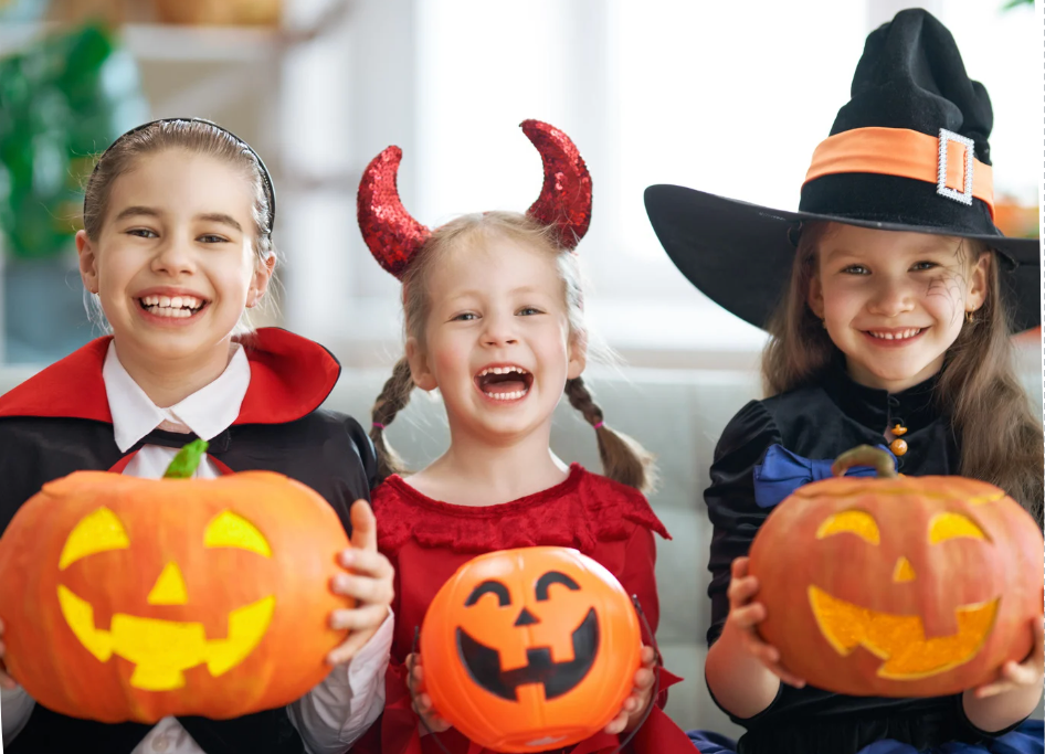 Children dressed up for Halloween holding carved pumkins