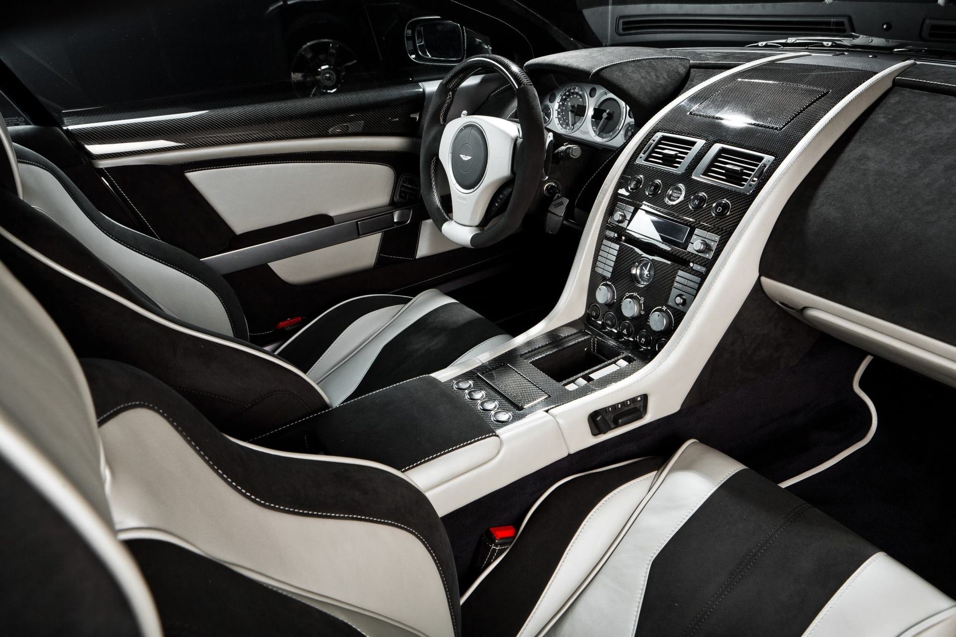 The interior of a black and white car with a steering wheel