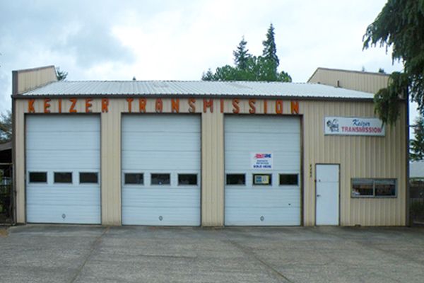 A building with a sign that says ' lenzer transmission ' on it
