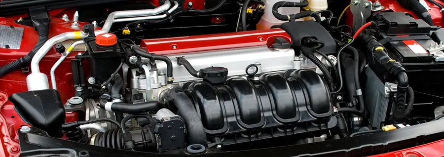 A close up of the engine of a red car.