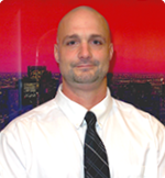 A bald man wearing a white shirt and black tie