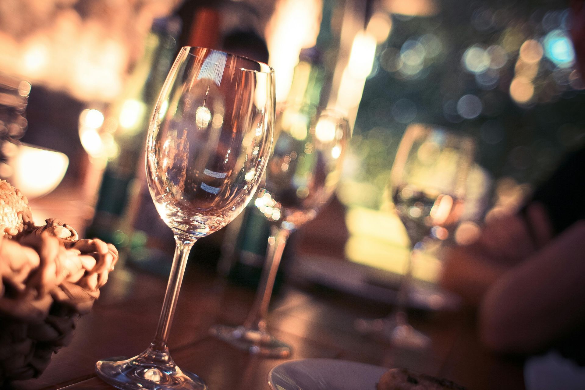 A row of wine glasses sitting on top of a wooden table.