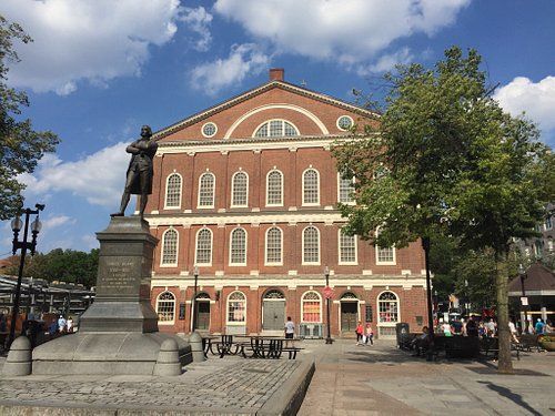 A large brick building with a statue in front of it.