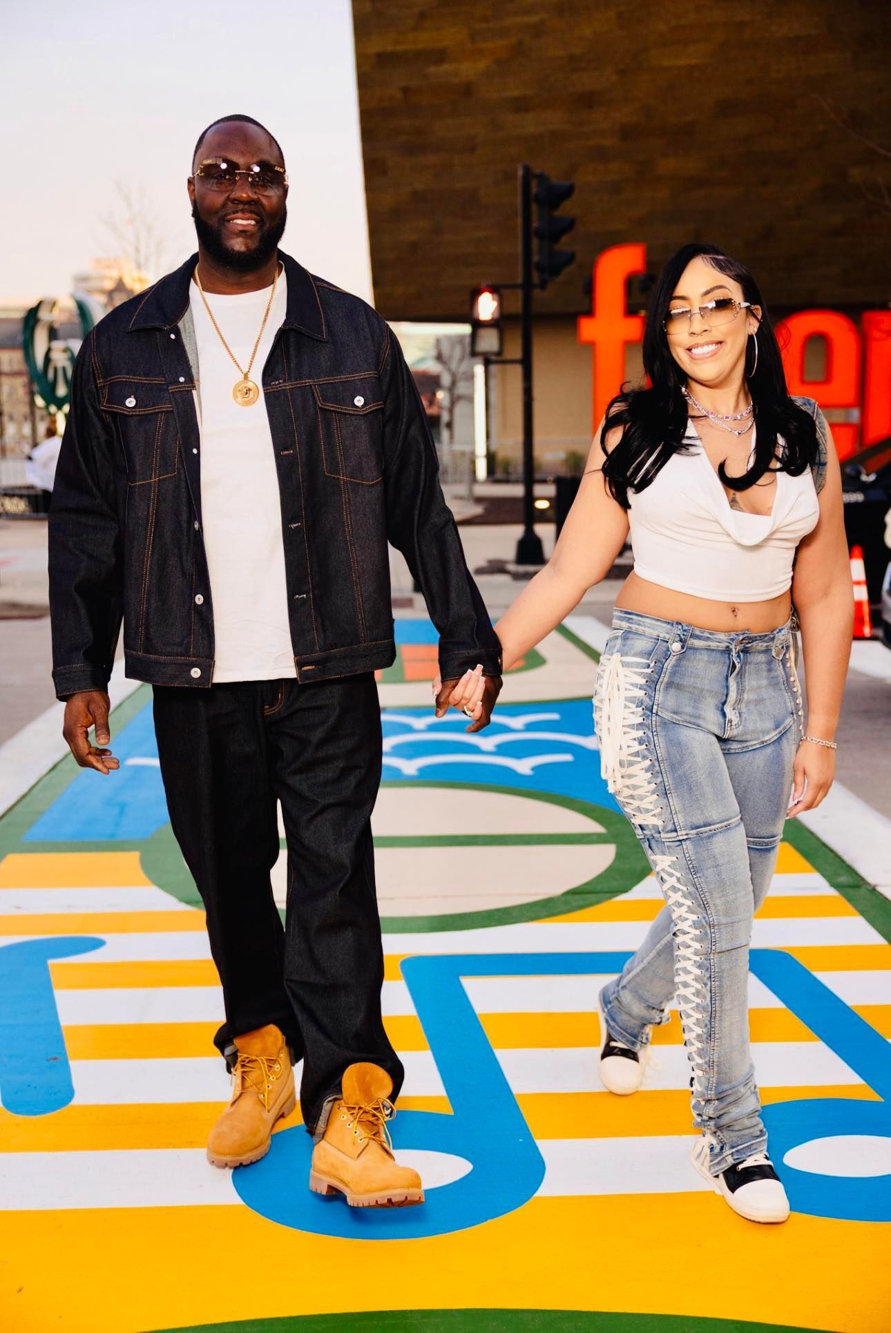 A man and two women are posing for a picture in front of balloons.