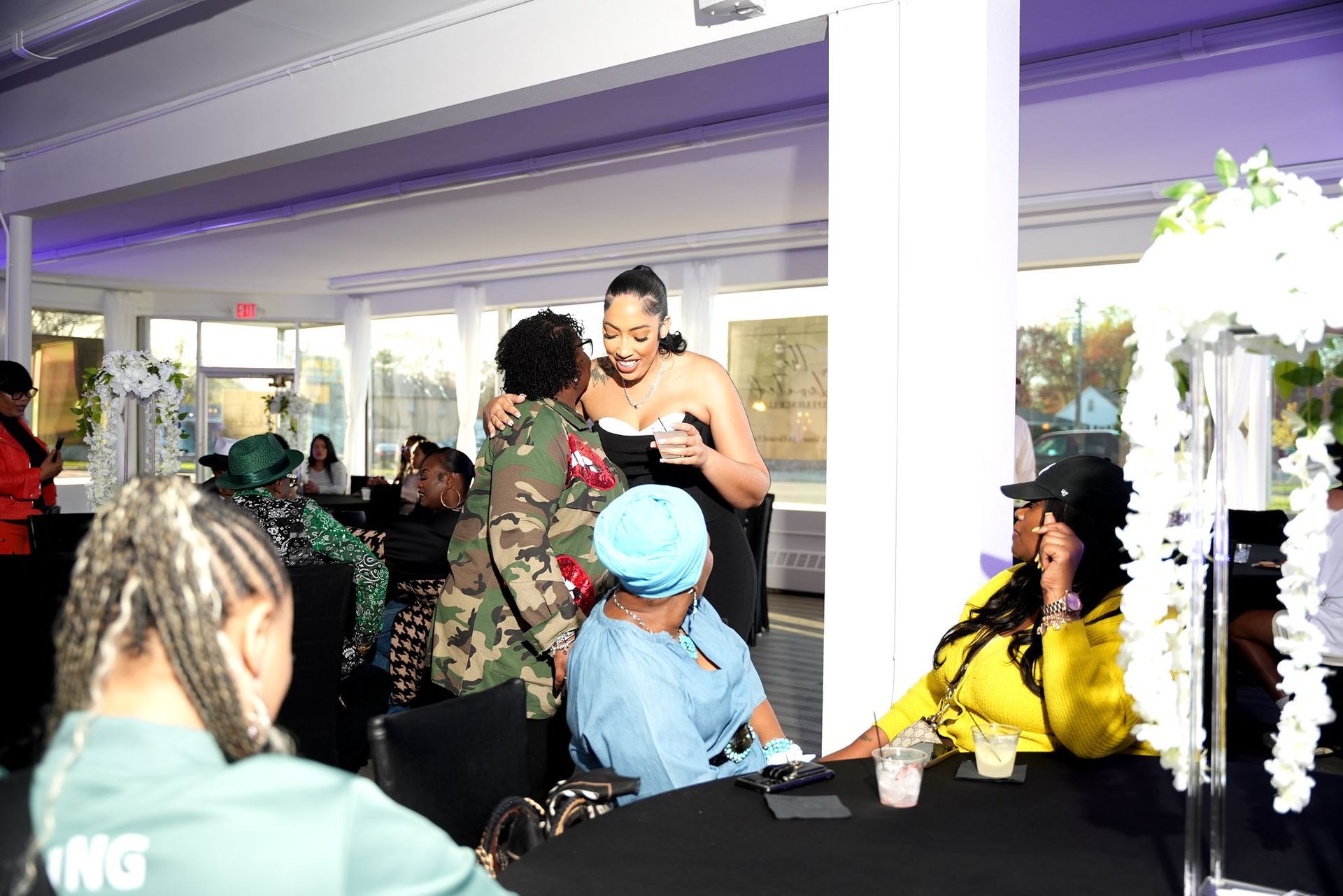 A group of women are sitting around a table at a party.