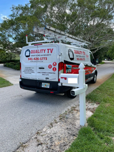 Quality TV Smart Home and Security service van on a residential street during home security camera and smart home installation in Florida. Quality TV Smart Home and Security service van on a residential street during home security camera and smart home installation in Florida.