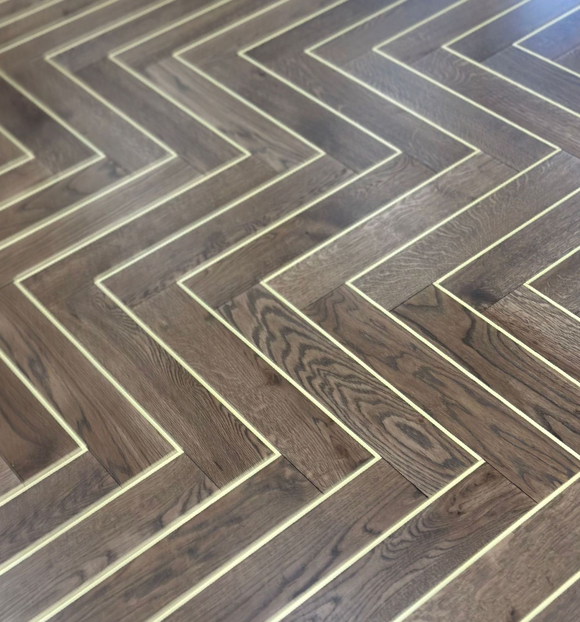 Herringbone flooring with metal inlay.